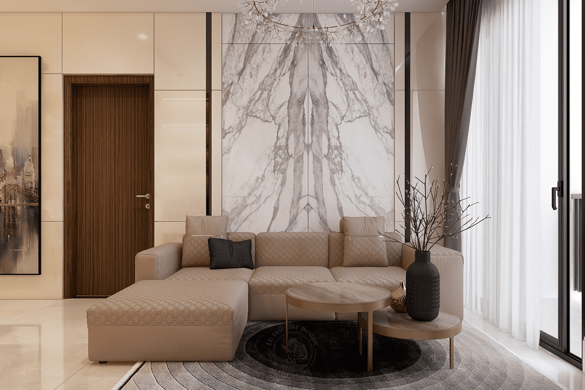Không gian phòng khách bố trí hệ sofa chữ L màu kem với bề mặt chần chỉ, đặt trước vách tường ốp đá marble vân mây đối xứng làm điểm nhấn xuyên suốt.