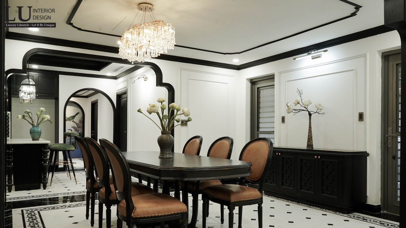 Không gian bàn ăn Indochine thực tế – Các vách ngăn họa tiết kết hợp đèn chùm, bàn ăn dài gỗ đen, ghế da sáng tạo sự sang trọng