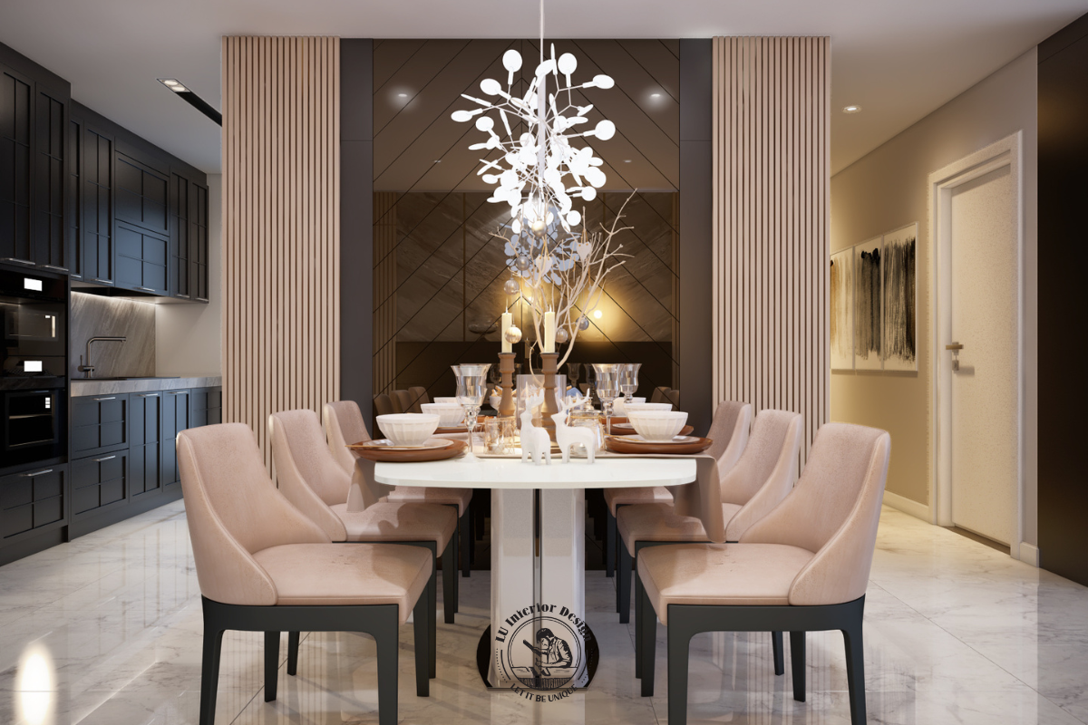 Bàn ăn lớn phối cùng ghế bọc nệm màu hồng beige, nổi bật dưới hệ đèn thả nhánh hoa và vách kính gương ghép nghệ thuật