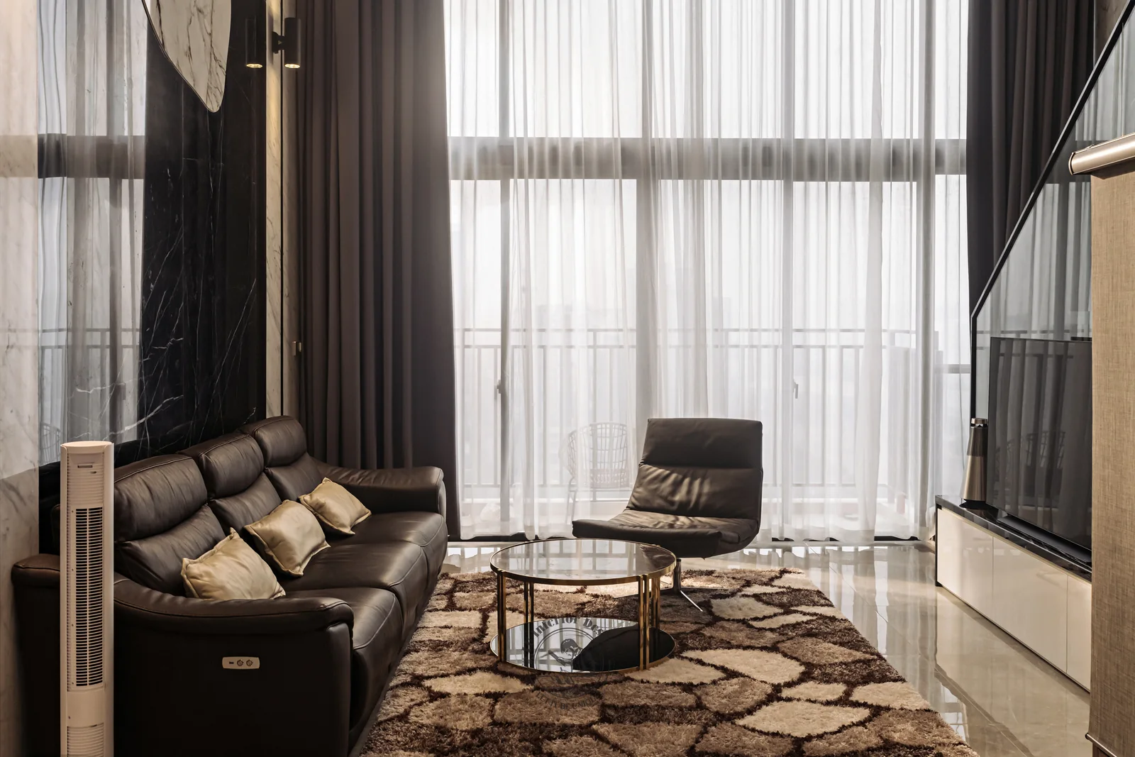 Sofa da đen và ghế thư giãn cạnh mảng kính lớn – hình ảnh thực tế công trình căn hộ Duplex The View 148m² – LU Design