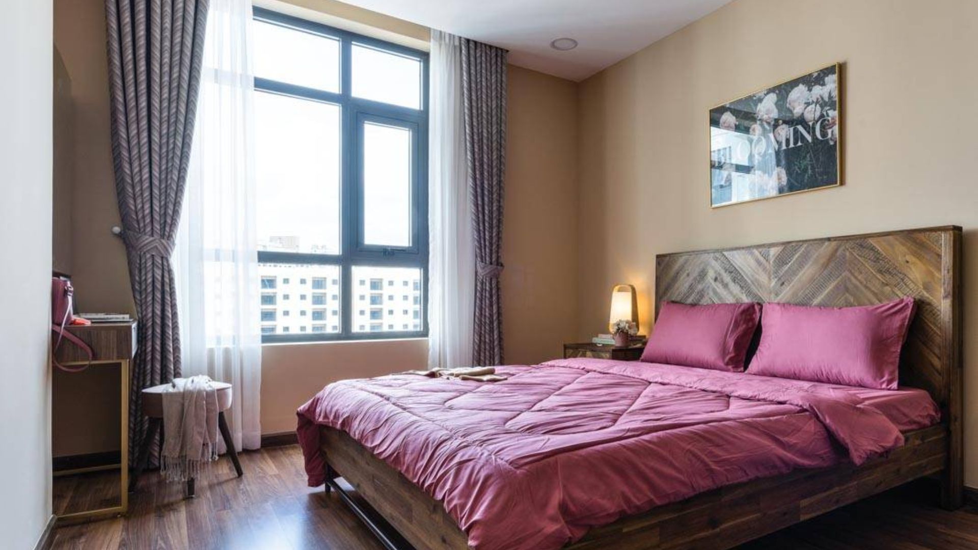 Giường ngủ được làm bằng gỗ kết hợp với ga giường màu hồng thể hiện sự tinh tế | Nguồn: Chung cư De Capella - Happynest. 